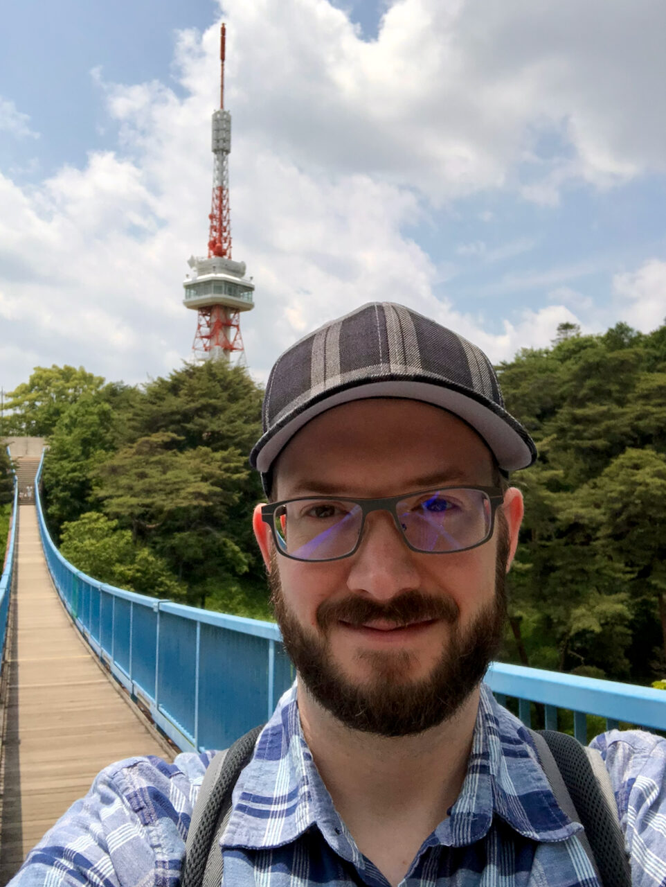 Calvin Freitas on a blue suspension bridge near Utsunomiya Tower in Utsunomiya, Japan
